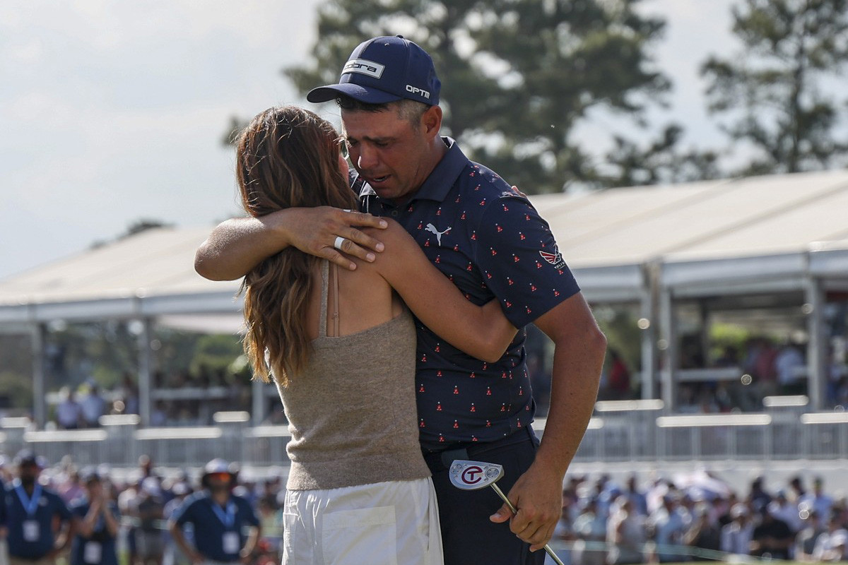 Manželka Gabby objímá Garyho Woodlanda (USA) po vítězství na Texas Children's Houston Open
