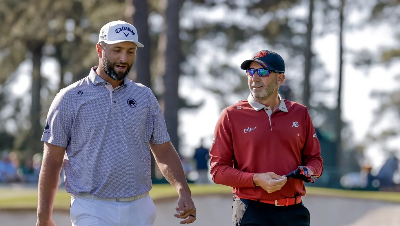 Jon Rahm (vlevo) a Sergio García odcházejí z odpaliště třetí jamky během finálového kola The Masters Tournament 2026