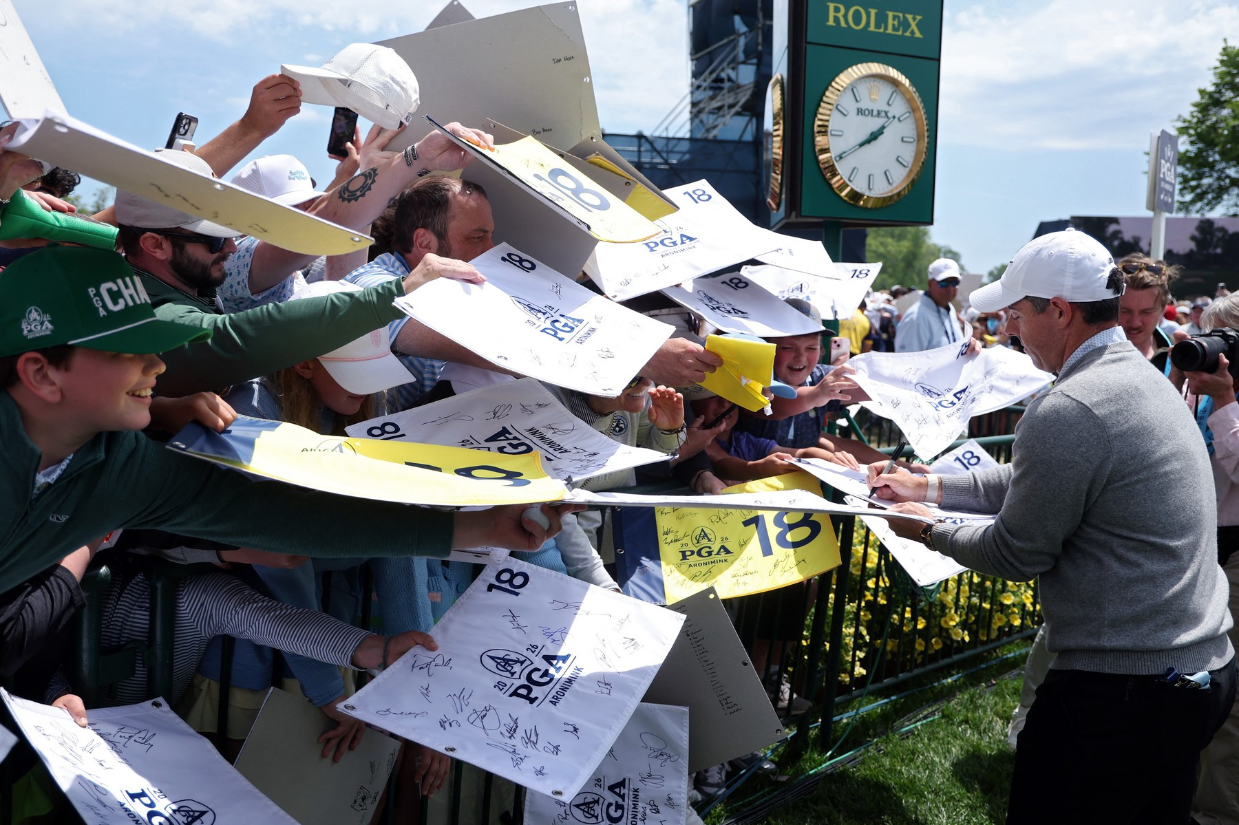 Rory McIlroy rozdává autogramy fanouškům během cvičného kola před turnajem PGA Championship v golfovém klubu Aronimink